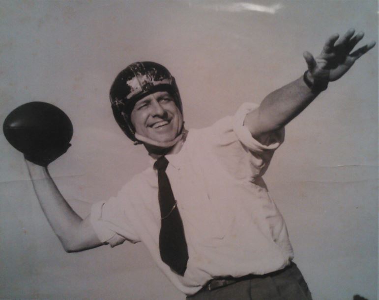 Judge Jack White in a football helmet, holding a football